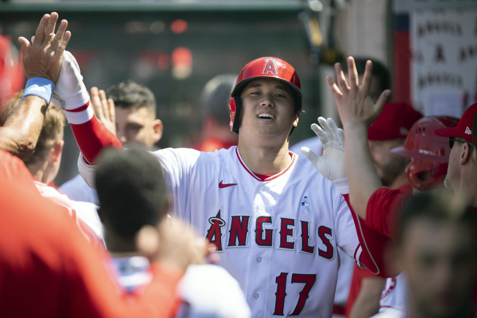 Los Angeles Angels' Shohei Ohtani is greeted in the dugout after hitting a two-run home run during the fifth inning of a baseball game against the Detroit Tigers in Anaheim, Calif., Sunday, June 20, 2021. (AP Photo/Kyusung Gong)