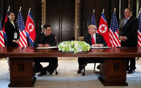 History in the making: Kim Jong-un and Donald Trump look at each other before signing the document - Credit: JONATHAN ERNST /Reuters