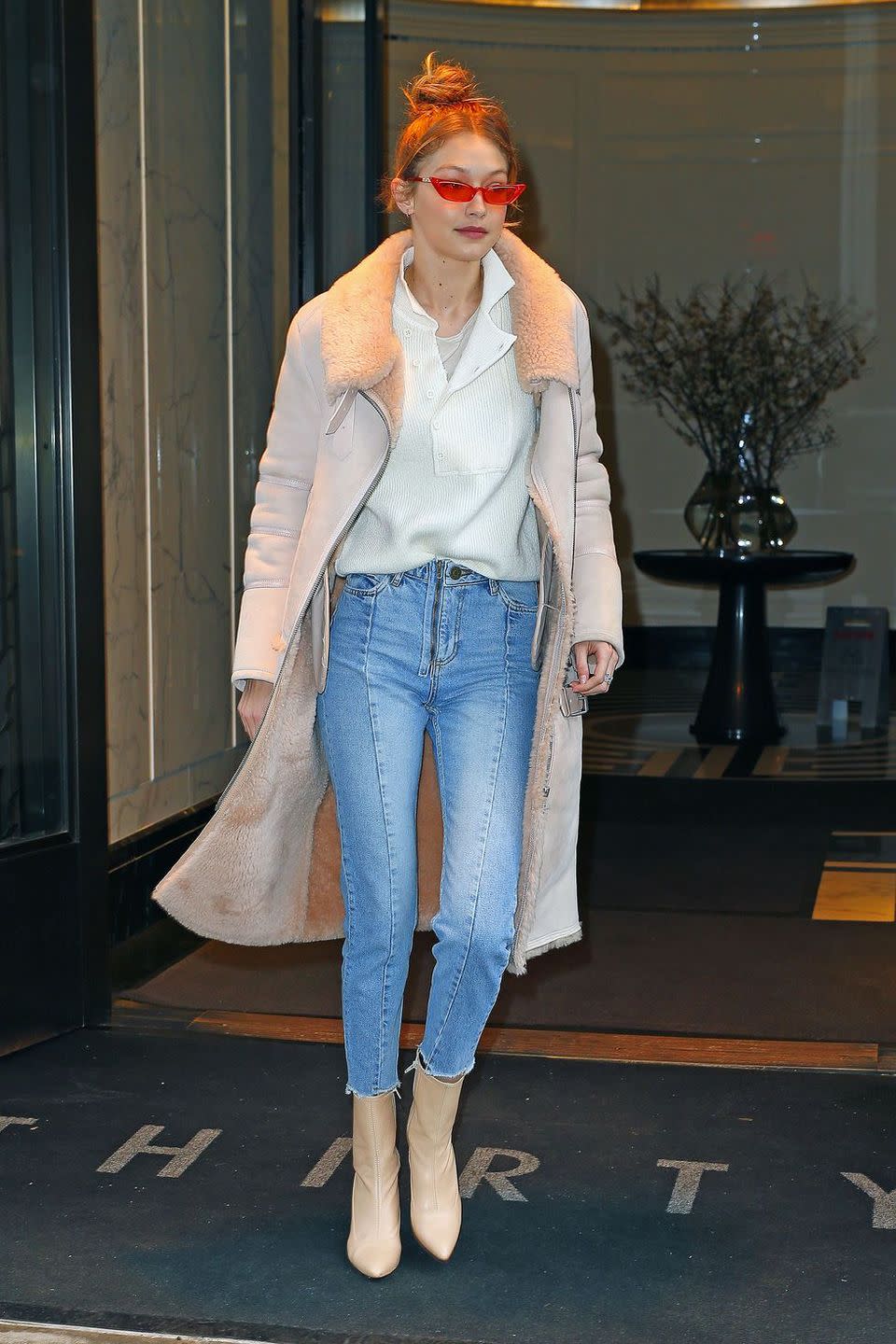 <p>In a fur-lined hushed pink coat by Iro Paris x Kith, white sweater, lightwash Sandro Paris jeans, tan boots, and orange sunglasses while out in NYC.</p>