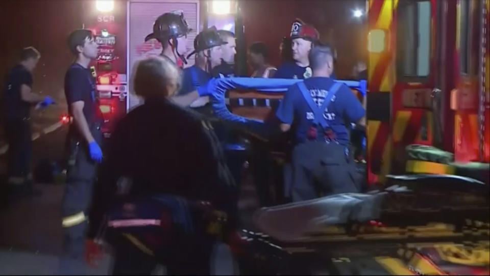 In this image from video, an emergency crew carries stretchers for injured persons after a light rail train was derailed in Sacramento, Calif., Thursday night, Aug. 22, 2019. Authorities say more than two dozen people have been injured in the light rail train derailment in Northern California. (KOVR via AP)