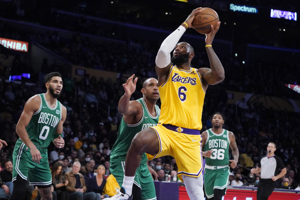 Los Angeles Lakers forward LeBron James (6) drives past Boston Celtics center Al Horford, center, during the second half of an NBA basketball game Tuesday, Dec. 7, 2021, in Los Angeles. (AP Photo/Marcio Jose Sanchez)
