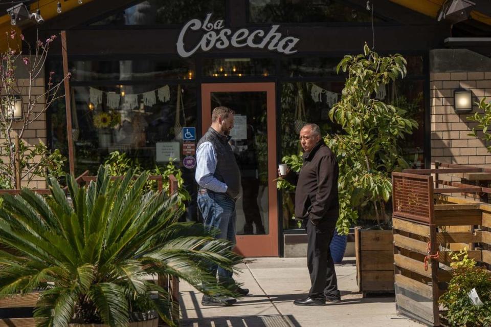 El exconcejal Steve Hansen habla con el propietario del restaurante La Cosecha, Ernesto Delgado, a principios de este mes en la César Chávez Plaza.