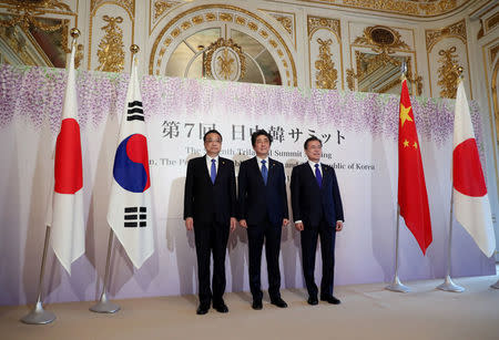 Chinese Premier Li Keqiang, Japanese Prime Minister Shinzo Abe and South Korean President Moon Jae-in pose for photographers prior to their summit in Tokyo, Wednesday, May 9, 2018. Eugene Hoshiko/Pool via Reuters