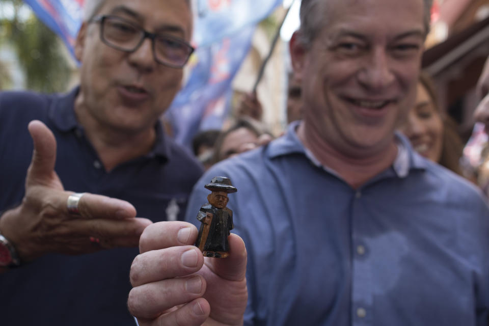 Ciro Gomes, presidential candidate with the Democratic Labor Party, shows a little statue of "Padre Cicero," a late priest who is venerated by Brazilian Christians, after a supporter gave it to him during his campaign rally in downtown Rio de Janeiro, Brazil, Wednesday, Sept. 12, 2018. Brazil will hold general elections on Oct. 7. (AP Photo/Leo Correa)