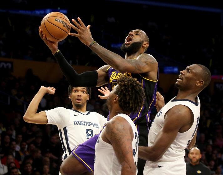 Los Angeles, CA - Lakers forward Lebron James drives to the basket against a trio of Grizzlies defenders.