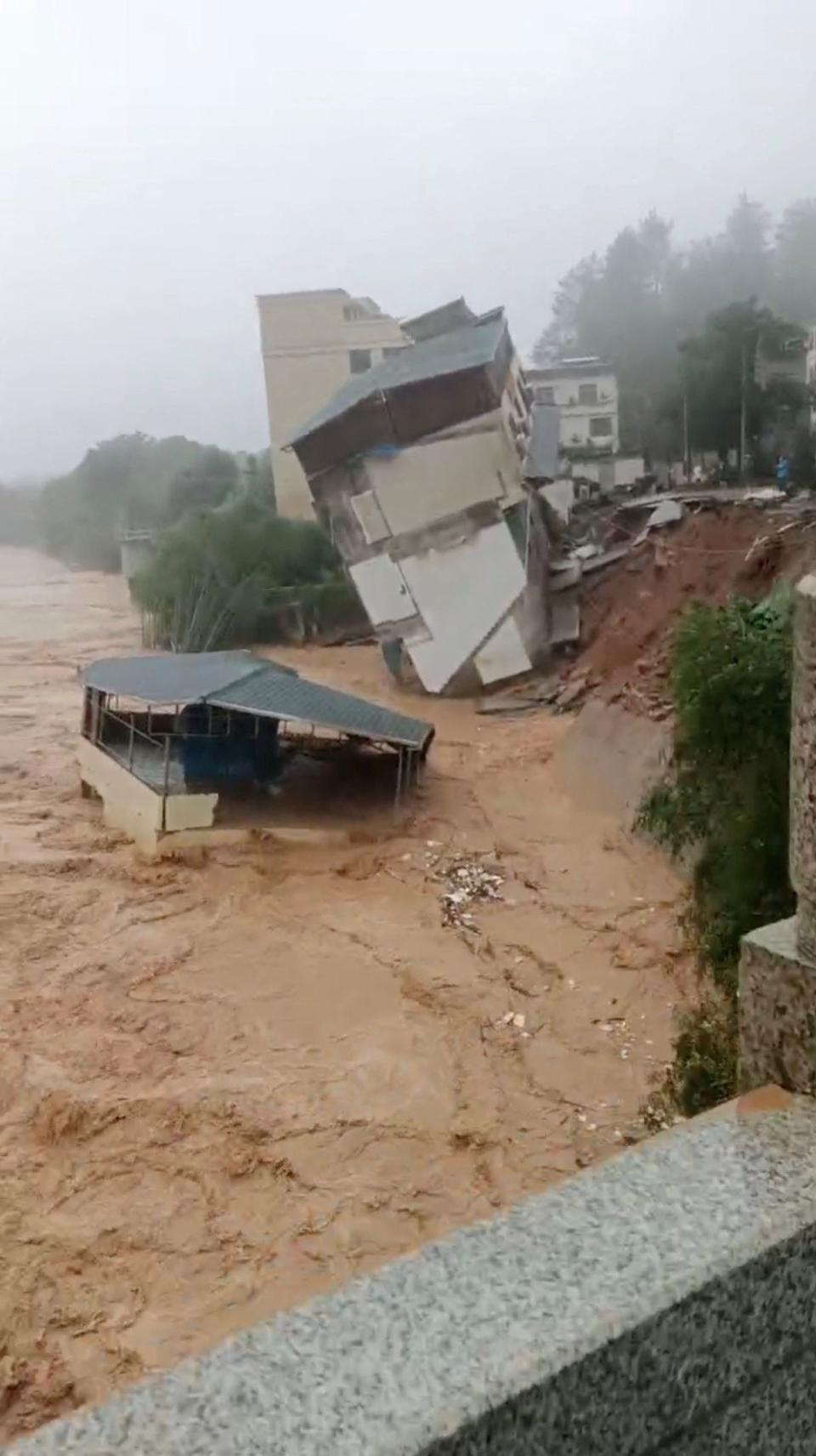廣東梅州建物因山洪暴發傾斜倒塌。（路透社）