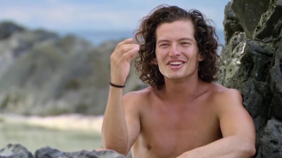 Jay Starett smiling during a confessional on a beach