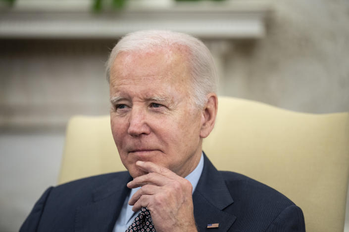 President Biden seated in a yellow chair.