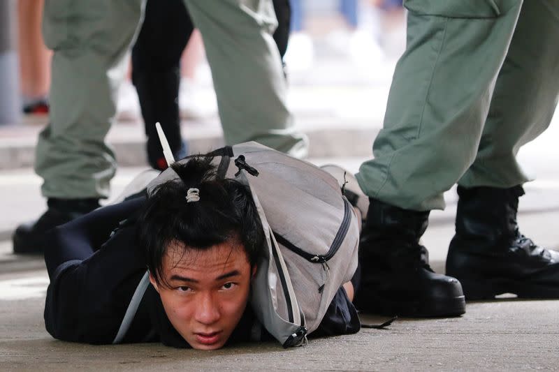 A man lies on the ground as he is detained by riot police during a march against the national security law at the anniversary of Hong Kong's handover to China from Britain in Hong Kong