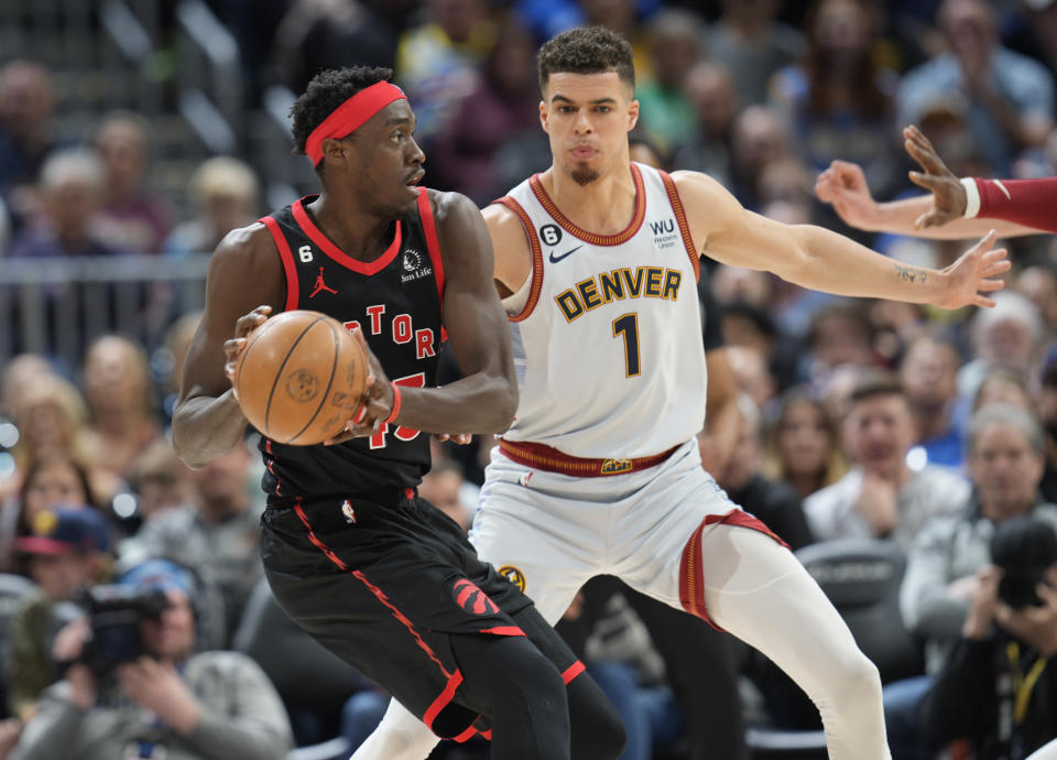 Toronto Raptors forward Pascal Siakam, left, looks to pass the ball as Denver Nuggets forward Michael Porter Jr. defends in the second half of an NBA basketball game, Monday, March 6, 2023, in Denver. (AP Photo/David Zalubowski)