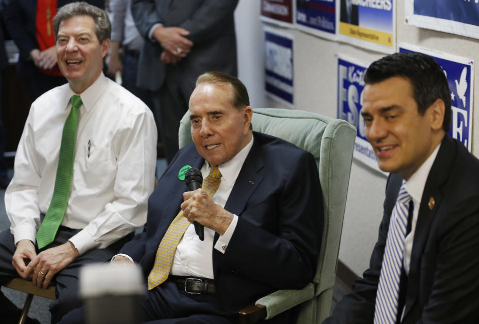 Former Sen. Bob Dole, R-Kan., center, takes questions while seated between Gov. Sam Brownback, left, and Rep. Kevin Yoder, R-Kan., right, during a visit to the Johnson County Republican Headquarters in Overland Park, Kan., Monday, April 21, 2014. (AP Photo/Orlin Wagner)