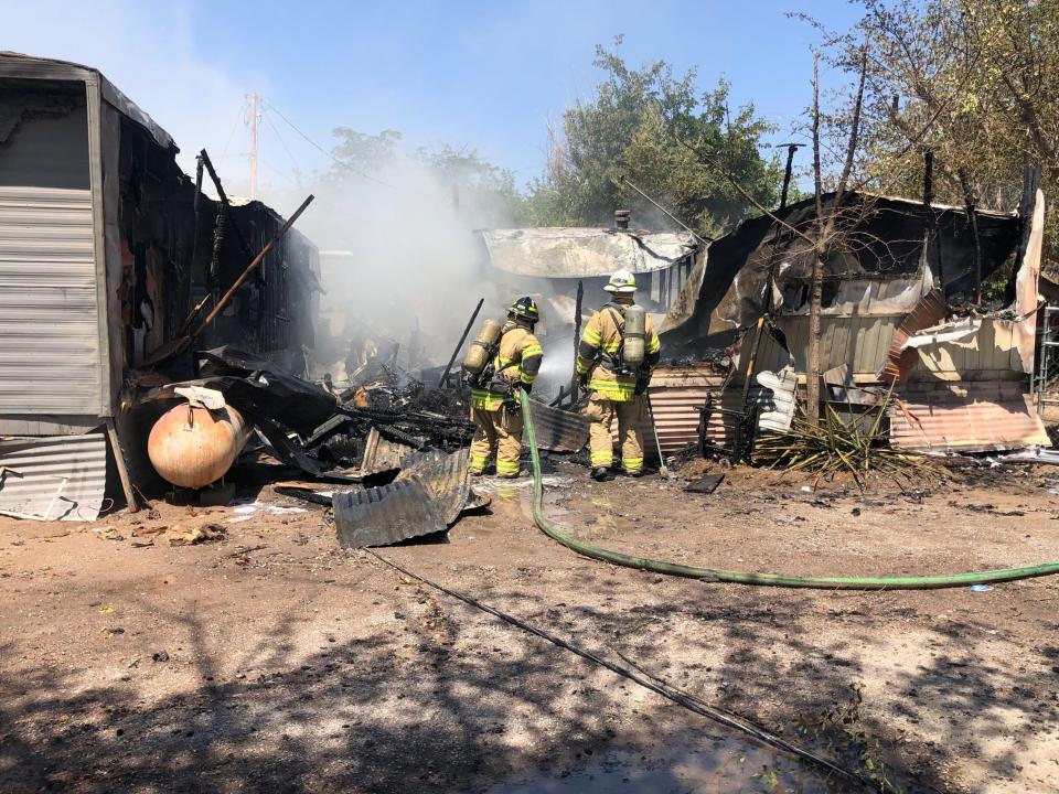 Las Cruces firefighters inspect what's left of a mobile home after a morning fire Monday, June 13, 2022. The mobile home was in a trailer park near 3 Crosses Avenue and Alameda Boulevard.