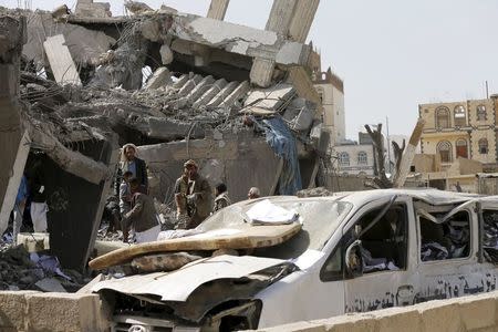 Houthi militants gather on the rubble of the offices of the education ministry's workers union, destroyed by Saudi-led air strikes, in Yemen's northwestern city of Amran August 19, 2015. REUTERS/Khaled Abdullah