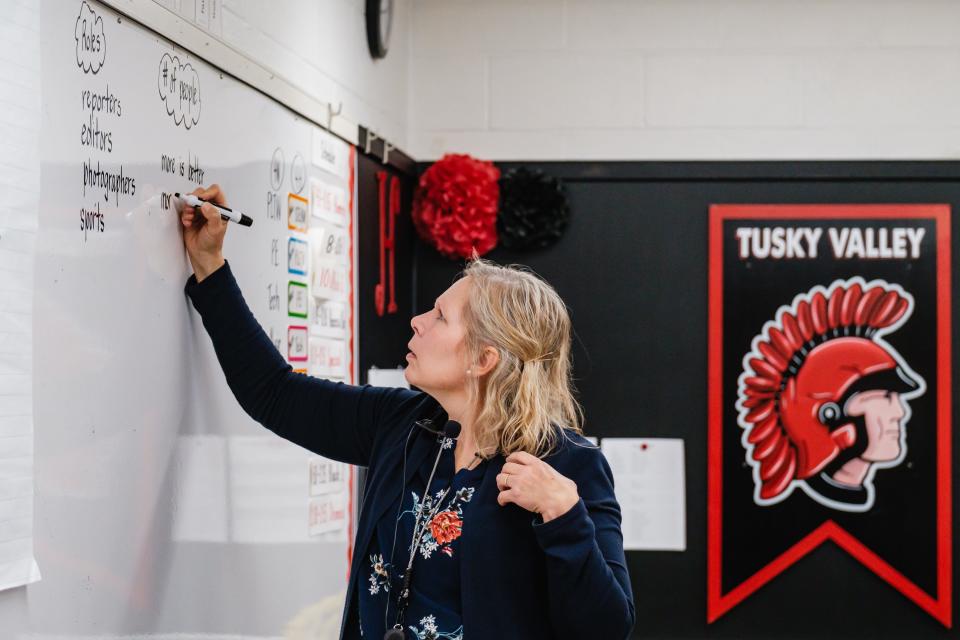 Jamie Horger, fourth grade math and science teacher at Tuscarawas Valley Intermediate School, makes notes on how to create a newspaper during a special after-school program. Times Reporter staff writer Jon Baker was invited to answer questions about the process of creating newspapers.