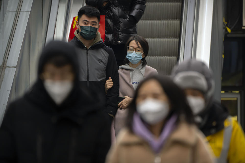 People wearing face masks ride an escalator at a shopping and office complex in Beijing, Wednesday, Jan. 11, 2023. Japan and South Korea on Wednesday defended their border restrictions on travelers from China, with Tokyo criticizing China's move to suspend issuing new visas in both countries as a step unrelated to virus measures. (AP Photo/Mark Schiefelbein)