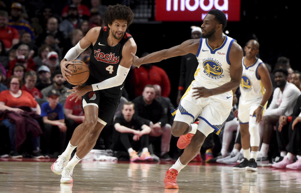 Portland Trail Blazers guard Matisse Thybulle, left, steals the ball as Golden State Warriors forward Andrew Wiggins, right, closes in during the first half of an NBA basketball game in Portland, Ore., Sunday, Dec. 17, 2023. (AP Photo/Steve Dykes)