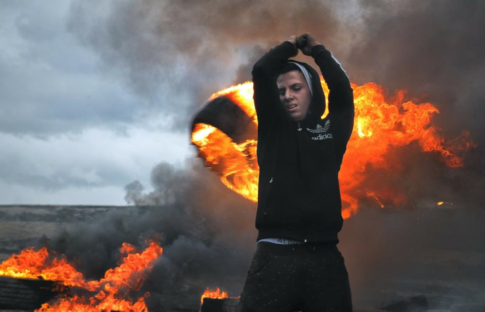 In this photo taken on Sunday, March 10, 2019, a young man spins a burning tire on a metal chain during a ritual marking the upcoming Clean Monday, the beginning of the Great Lent, 40 days ahead of Orthodox Easter, on the hills surrounding the village of Poplaca, in central Romania's Transylvania region. Romanian villagers burn piles of used tires then spin them in the Transylvanian hills in a ritual they believe will ward off evil spirits as they begin a period of 40 days of abstention, when Orthodox Christians cut out meat, fish, eggs, and dairy. (AP Photo/Vadim Ghirda)