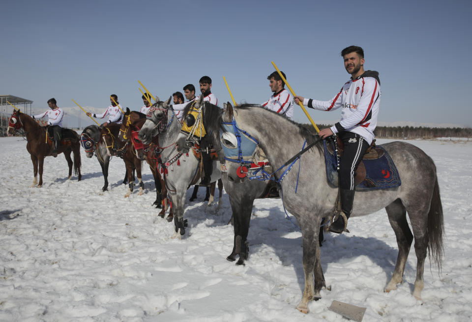 Riders, members of the Dadas (Comrades) local sporting club, gather for a game of Cirit, a traditional Turkish equestrian sport that dates back to the martial horsemen who spearheaded the historical conquests of central Asia's Turkic tribes, between the Comrades and the Experts local sporting clubs, in Erzurum, eastern Turkey, Friday, March 5, 2021. The game that was developed more than a 1,000 years ago, revolves around a rider trying to spear his or her opponent with a "javelin" - these days, a rubber-tipped, 100 centimeter (40 inch) length of wood. A rider from each opposing team, which can number up to a dozen players, face each other, alternately acting as the thrower and the rider being chased. Cirit was popular within the Ottoman empire, before it was banned as in the early 19th century. However, its popularity returned as is now one of many traditional sports encouraged by the government and tournaments are often arranged during festivals or to celebrate weddings. (AP Photo/Kenan Asyali)