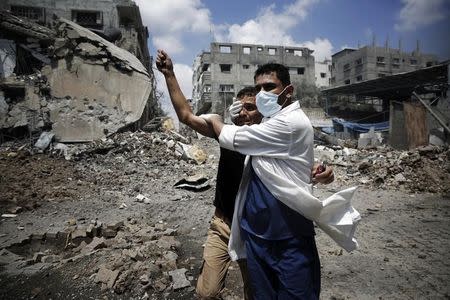 A medic helps a Palestinian in the Shejaia neighbourhood, which was heavily shelled by Israel during fighting, in Gaza City July 20, 2014. REUTERS/Finbarr O'Reilly