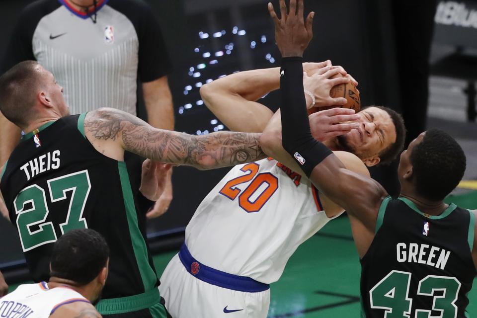 Boston Celtics' Daniel Theis (27) and Javonte Green (43) battle New York Knicks' Kevin Knox II (20) for a rebound during the first half of an NBA basketball game, Sunday, Jan. 17, 2021, in Boston. (AP Photo/Michael Dwyer)
