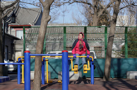 A woman exercises as blue sky returns after winds dispelled dangerously high levels of air pollution in Beijing, China December 22, 2016. REUTERS/Jason Lee