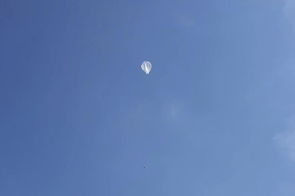 In this image taken from a video shot by Tom Medlin on June 11, 2022, a pico balloon, which costs about $12 and is about 32 inches in diameter, floats in the air near Collierville, Tenn. Medlin, owner of the Amateur Radio Roundtable podcast, believes a similar balloon is what the U.S. military shot down over the Yukon recently. Hobbyists typically fly the balloons for fun and to experience the challenge of building transmitters and antenna systems, although the National Oceanic and Atmospheric Administration has been collecting data from operators to learn more about wind patterns, he said. (Tom Medlin via AP)