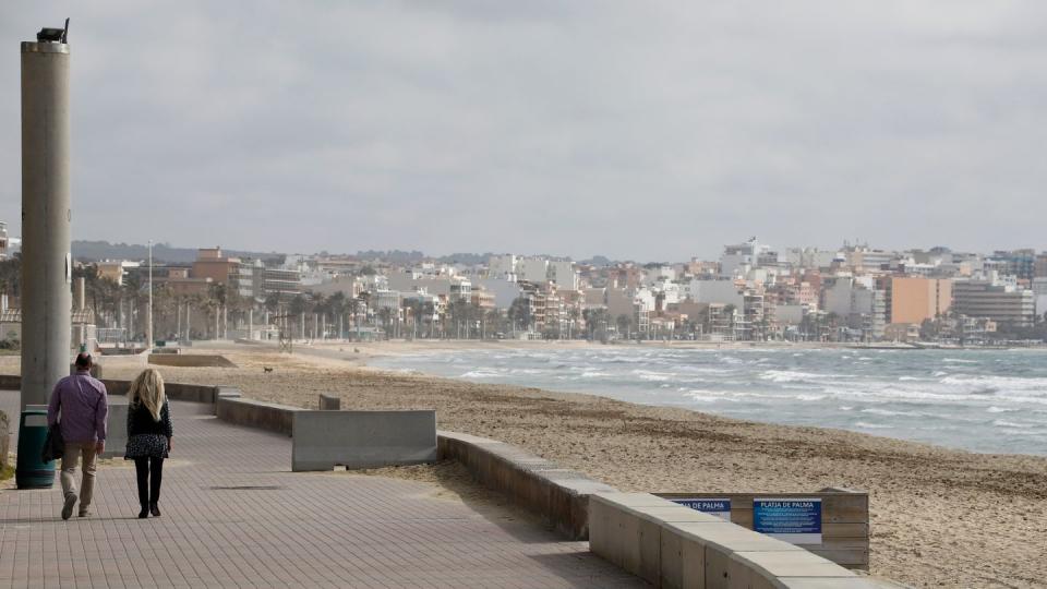 Spaziergänger auf der Promenade am Strand von Arenal.