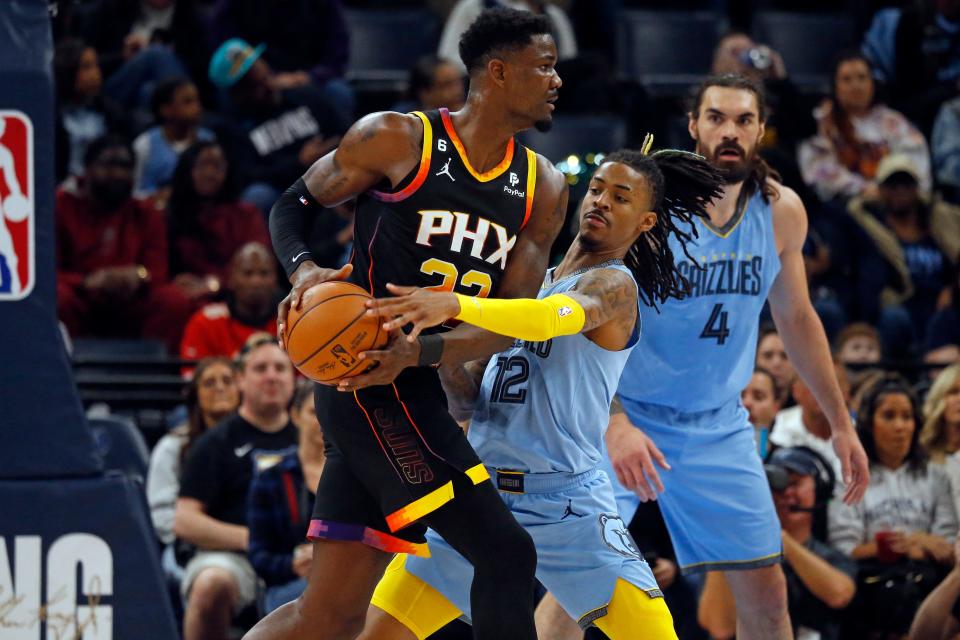 Jan 16, 2023; Memphis, Tennessee, USA; Memphis Grizzlies guard Ja Morant (12) defends Phoenix Suns center Deandre Ayton (22) during the first half at FedExForum.