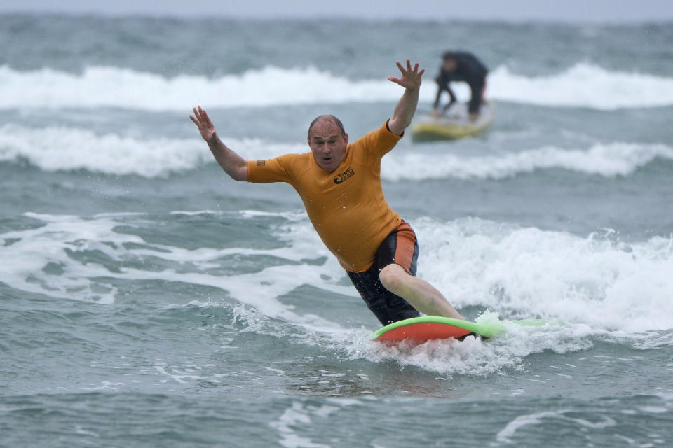 Liberal Democrat leader Sir Ed Davey falls from a surfboard during a visit to Big Blue Surf School in Bude in Cornwall, England, Tuesday July 2, 2024, while on the General Election campaign trail. United Kingdom voters will cast ballots in a national election Thursday, passing judgment on Sunak’s 20 months in office, and on the four Conservative prime ministers before him. (Matt Keeble/PA via AP)