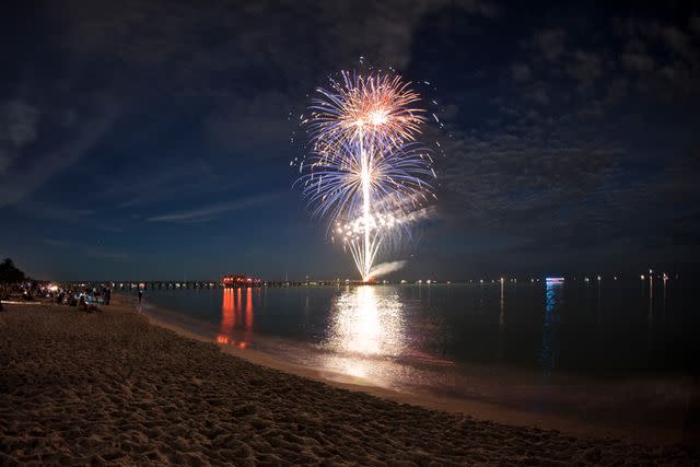 <p>Getty</p> Stock image of fireworks over a beach.