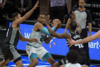 Charlotte Hornets forward P.J. Washington (25) is defended by Sacramento Kings guard Cory Joseph, left, and Sacramento Kings forward Harrison Barnes (40) during the second half of an NBA basketball game in Sacramento, Calif., Sunday, Feb. 28, 2021. The Hornets won 127-126. (AP Photo/Randall Benton)