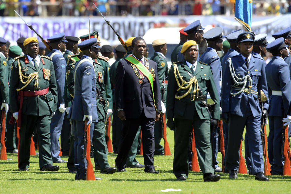 Zimbabwean President Emmerson Mnangagwa, center, inspects the guard of honour during his inauguration ceremony at the National Sports Stadium in Harare, Sunday, Aug. 26, 2018. Zimbabwe on Sunday inaugurated a president for the second time in nine months as a country recently jubilant over the fall of longtime leader Robert Mugabe is now largely subdued by renewed harassment of the opposition and a bitterly disputed election. (AP Photo/Tsvangirayi Mukwazhi)