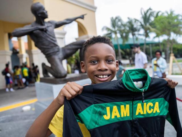 Mason Barreau, 10, holds his jacket in front of the newly unveiled bronze sculpture of Olympic gold medalist Usain Bolt at the Ansin Sports Complex on Saturday, July 15, 2023, in Miramar, Fla.