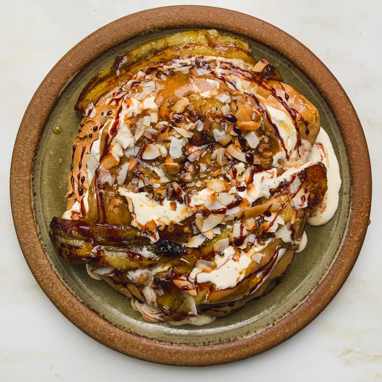 <span>Tom Hunt's brown sugar pavlova made with brown banana curd, flambe banana, cream, toasted coconut and date syrup.</span><span>Photograph: Tom Hunt/The Guardian</span>