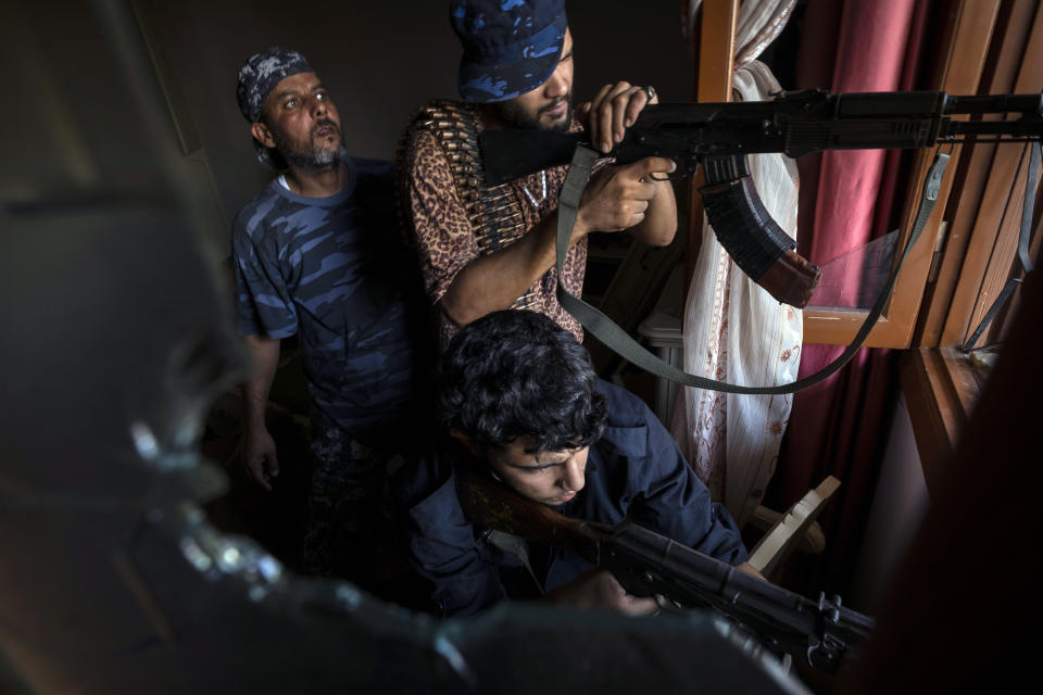 FILE - In this Aug 31, 2019 file photo, fighters of the 'Shelba' unit, a militia allied with the U.N.-supported Libyan government, aim at enemy positions at the Salah-addin neighborhood front line in Tripoli, Libya. Two Libyan militia commanders and a Syrian war monitor group say Turkey is deploying Syrian extremists to fight in Libya's civil war. These extremists are affiliated with groups like al-Qaida and the Islamic State. They're fighting as mercenaries on behalf of the United Nations-supported government in Libya. The Libyan sources told The Associated Press that Turkey has airlifted more than 2,500 foreign fighters into Tripoli, and that “dozens” are extremist-affiliated. (AP Photo/Ricard Garcia Vilanova, File)