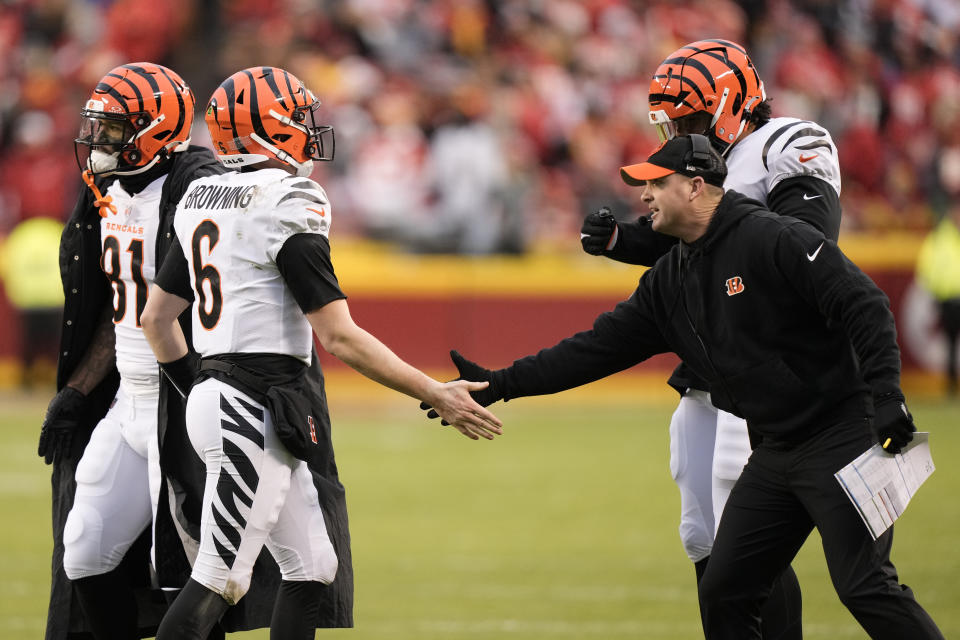 Cincinnati Bengals quarterback Jake Browning (6) is congratulated by Bengals head coach Zac Taylor after scoring during the first half of an NFL football game against the Kansas City Chiefs Sunday, Dec. 31, 2023, in Kansas City, Mo. (AP Photo/Charlie Riedel)