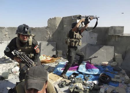 Members of the Iraqi Special Operations Forces take their positions during clashes with the al Qaeda-linked Islamic State of Iraq and the Levant (ISIL) in the city of Ramadi June 19, 2014. REUTERS/Stringer