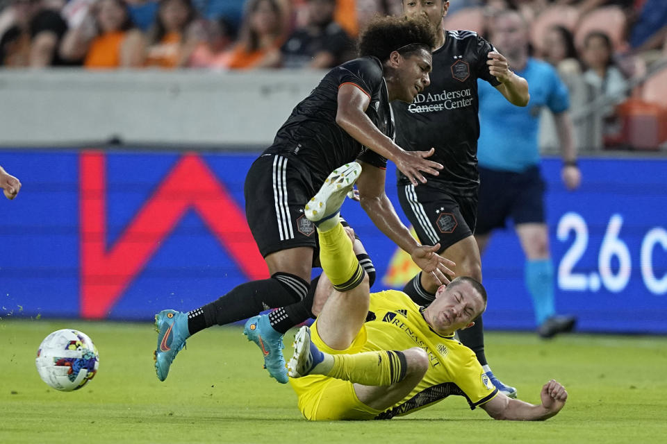 Houston Dynamo's Adalberto Carrasquilla, left, is fouled by Nashville SC's Alex Muyl during the first half of a soccer match Saturday, May 14, 2022, in Houston. (AP Photo/David J. Phillip)