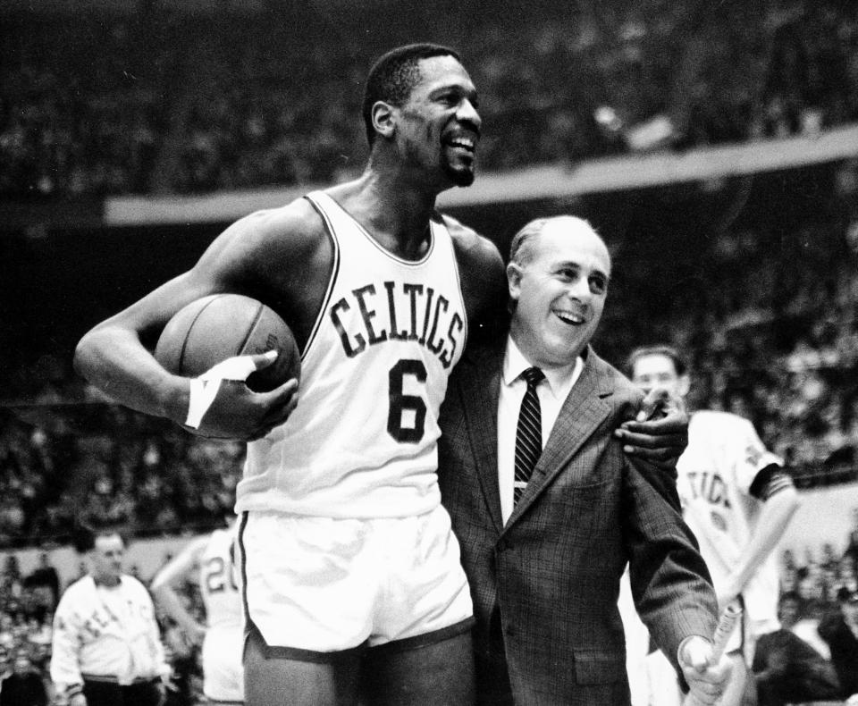 FILE - In this Dec. 12, 1964 file photo, Boston Celtics' Bill Russell, left,  is congratulated by coach Arnold "Red" Auerbach after scoring his 10,000th career point during a basketball game against the Baltimore Bullets at the Boston Garden in Boston. As a coach, Red Auerbach got the most out of Bill Russell as a player not by yelling at him, or teaching him new techniques. He just talked to him man-to-man. Russell celebrates their relationship in a new book about Auerbach. (AP Photo/Bill Chaplis)