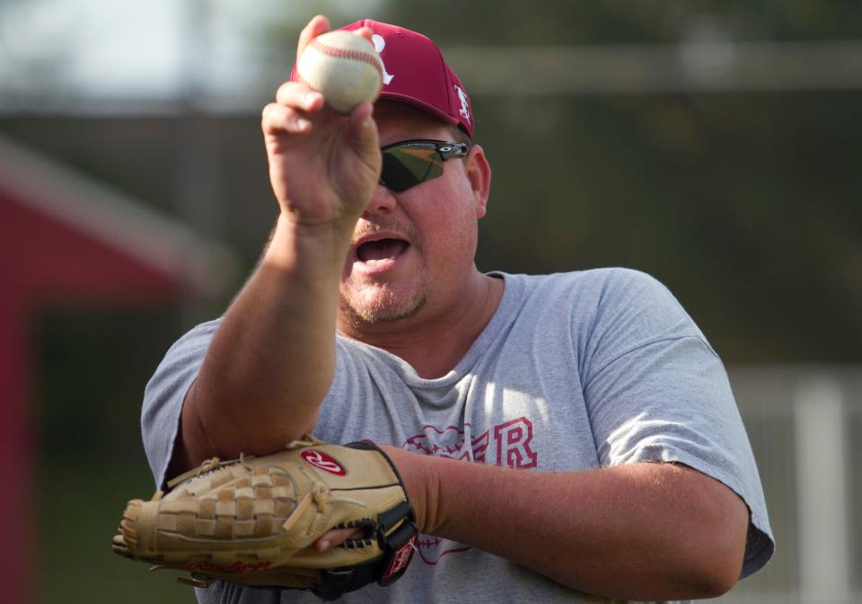 Bob Pringle demonstrates safe throwing techniques to his baseball team at Riverdale on Thursday.
