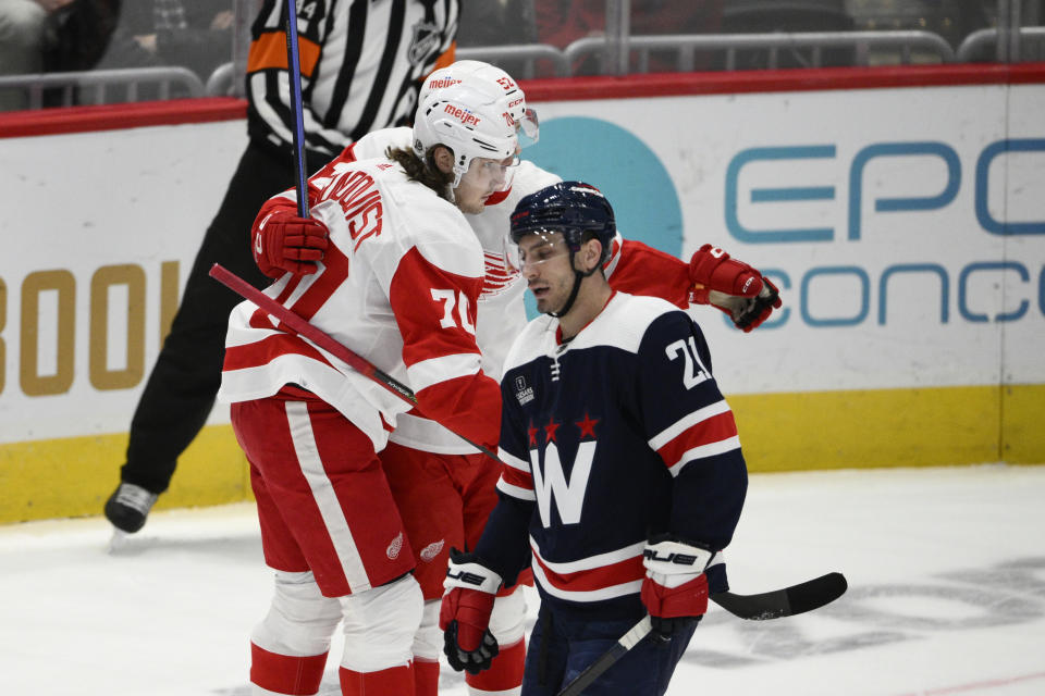 Detroit Red Wings center Oskar Sundqvist (70) celebrates his goal with teammate Jonathan Berggren (52) next to Washington Capitals right wing Garnet Hathaway (21) during the first period of an NHL hockey game Monday, Dec. 19, 2022, in Washington. (AP Photo/Nick Wass)