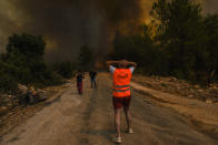 FILE - In this Sunday, Aug. 1, 2021 file photo, people run away from the fire-devastated Sirtkoy village, near Manavgat, Antalya, Turkey. Scientists say there’s something different this year from the recent drumbeat of climate weirdness. This summer a lot of the places hit by weather disasters are not used to getting extremes and many of them are wealthier, which is different from the normal climate change victims. That includes unprecedented deadly flooding in Germany and Belgium, 116-degree heat records in Portland, Oregon and similar blistering temperatures in Canada, along with wildfires. Now Southern Europe is seeing scorching temperatures and out-of-control blazes too. And the summer of extremes is only getting started. Peak Atlantic hurricane and wildfire seasons in the United States are knocking at the door. (AP Photo, File)