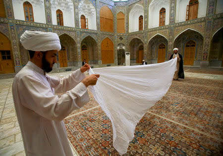 A Shi'ite cleric holds a turban at al-sayed al-Yazdi school run by al-Hawza al-Ilmiyya in Najaf, Iraq, August 12, 2017. For more than 1,000 years, the al-Hawza al-Ilmiyya in southern Baghdad has been giving religious instructions to thousands of Shi'ite Muslims to help them become clerics. REUTERS/Abdullah Dhiaa Al-deen