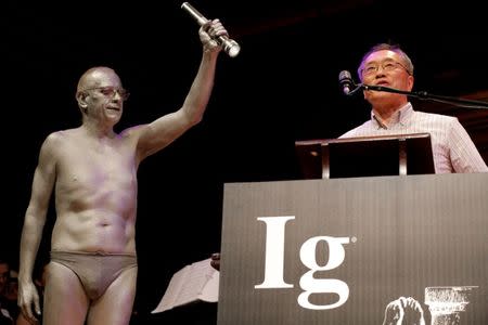 Atsugi Higashiyama of Japan accepts the 2016 Ig Nobel Prize in Perception for "investigating whether things look different when you bend over and view them between your legs" during the 26th First Annual Ig Nobel Prize ceremony at Harvard University in Cambridge, Massachusetts, U.S. September 22, 2016. REUTERS/Brian Snyder