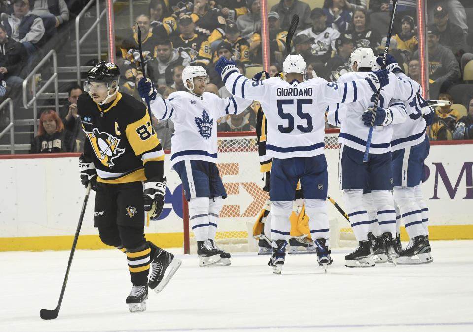 Pittsburgh Penguins center Sidney Crosby (87) skates away as the Toronto Maple Leafs celebrate a goal by right wing William Nylander during the second period of an NHL hockey game, Saturday, Nov. 26, 2022, in Pittsburgh. (AP Photo/Philip G. Pavely)