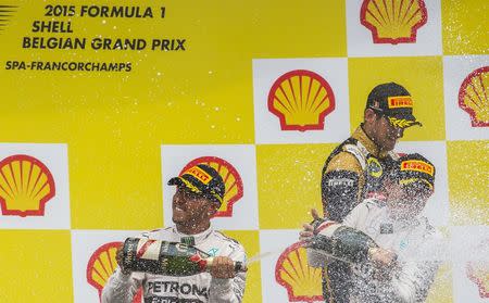 Mercedes Formula One driver Lewis Hamilton of Britain (L) celebrates his victory with teammate Nico Rosberg of Germany (R) who took the second place in the Belgian F1 Grand Prix in Spa-Francorchamps August 23, 2015. REUTERS/Yves Herman