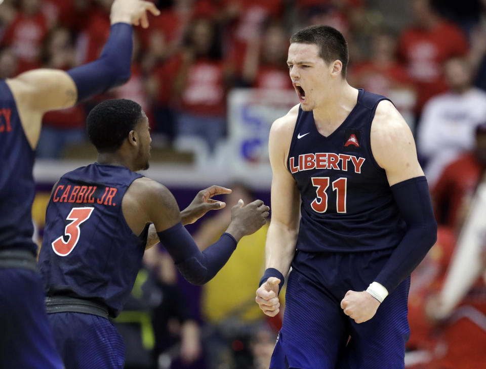 Liberty forward Scottie James (31) celebrates with Lovell Cabbil Jr. (3) after James made a free throw late in the second half of the Atlantic Sun NCAA college basketball tournament championship game against Lipscomb Sunday, March 10, 2019, in Nashville, Tenn. Liberty won 74-68. (AP Photo/Mark Humphrey)