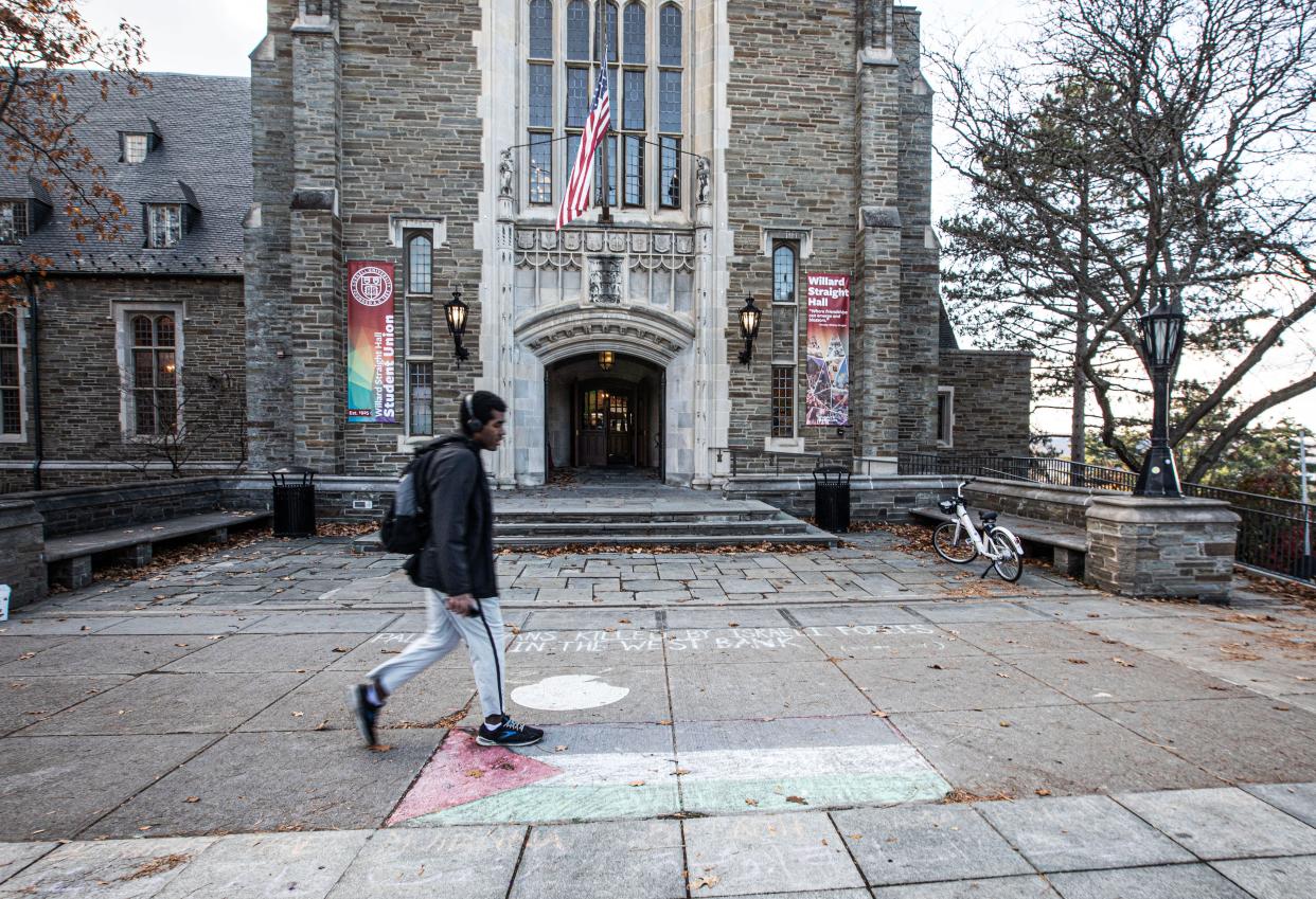 A student walks past a Palestinian flag drawn in chalk on the Cornell University campus Nov. 5, 2023. In the days after the start of the war between Israel and Hamas, pro-Palestinian students also wrote the names of Palestinians killed in the West Bank.