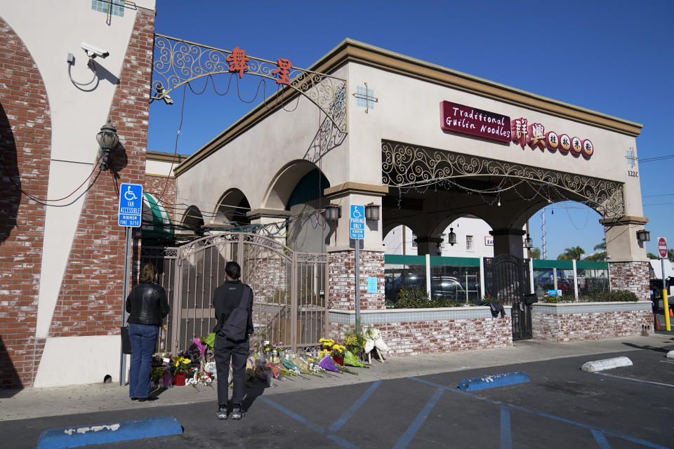 Two people pause at a memorial outside the Star Ballroom Dance Studio on Monday, Jan. 23, 2023, in Monterey Park, Calif. A gunman killed multiple people at the ballroom dance studio late Saturday amid Lunar New Year's celebrations in the predominantly Asian American community. (AP Photo/Ashley Landis)