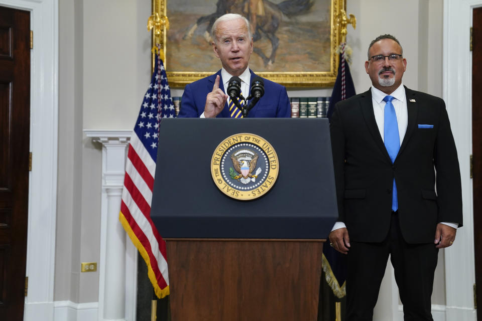 FILE - President Joe Biden speaks about student loan debt forgiveness in the Roosevelt Room of the White House, Aug. 24, 2022, in Washington. Education Secretary Miguel Cardona listens at right. The Black Lives Matter Global Network Foundation launched a new relief fund Monday, Dec. 12, 2022 aimed at Black college students, alumni and dropouts overburdened by mounting education costs and the student loan debt crisis. President Biden said the government would forgive $10,000 in student loan debt for Americans with annual incomes below $125,000. More than 26 million people had already applied for the relief, with 16 million approved. But the government stopped processing applications in November, after a federal judge in Texas struck down the plan. Conservative attorneys and Republican lawmakers are challenging the legality of the debt forgiveness plan on an argument that Biden cannot take this step without congressional approval. (AP Photo/Evan Vucci, file)